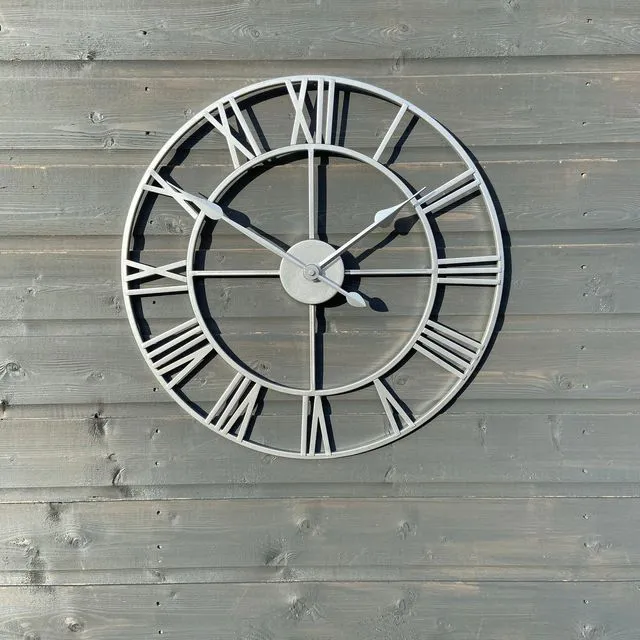 Silver framed Skeleton clock with silver numerals and silver hands